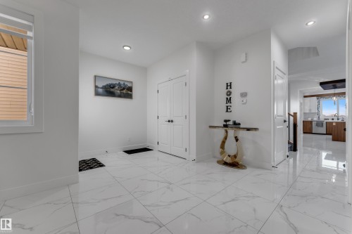 White tile flooring, recessed lighting, white walls, white doors, and a window with blinds - 6502 42 Ave, Beaumont, AB 