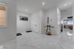 White tile flooring, recessed lighting, white walls, white doors, and a window with blinds - 