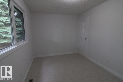 Neutral wall finishes, window with a white frame, light-colored carpet flooring, white paneled door, and recessed lighting - 44 Arlington Drive, St. Albert, AB 