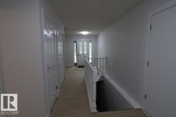 Entryway featuring wood-finish flooring, white paneled doors, and a decorative glass entry door - 