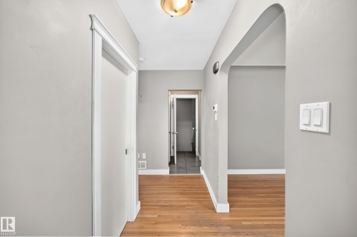 Hardwood flooring throughout, recessed archway, light-toned wall finishes, and ceiling-mounted light fixture - 10715 133 Street Nw, Edmonton, AB 