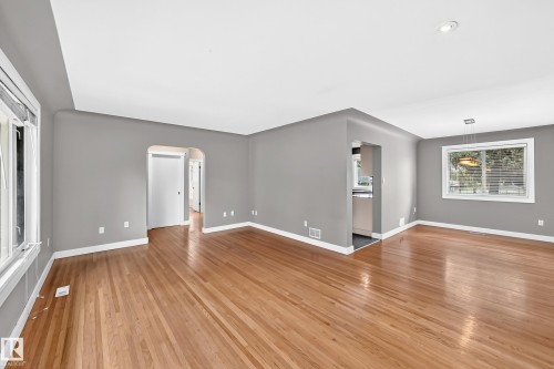 Hardwood flooring throughout, recessed lighting, and a modern chandelier - 10715 133 Street Nw, Edmonton, AB 
