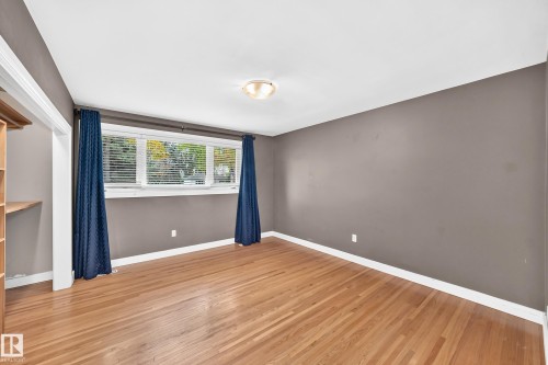 Hardwood flooring, neutral wall tones, window with natural light, built-in shelving, and overhead lighting - 10715 133 Street Nw, Edmonton, AB 