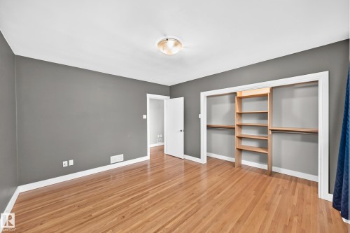 Hardwood flooring throughout, featuring a built-in closet system with shelving and hanging rods - 10715 133 Street Nw, Edmonton, AB 
