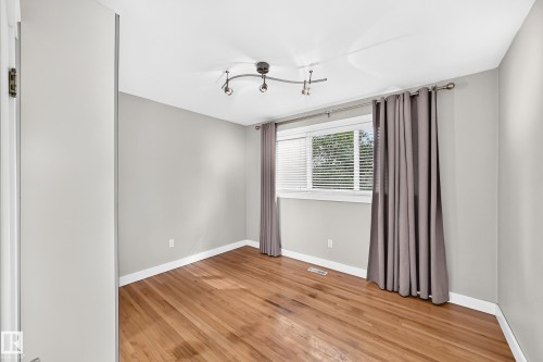 Hardwood flooring, track lighting fixture, white window blinds, and light gray wall finishes - 10715 133 Street Nw, Edmonton, AB 
