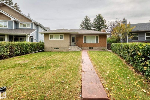 Brick and stucco exterior, front walkway, mature front yard landscaping, and an asphalt shingle roof - 10715 133 Street Nw, Edmonton, AB 