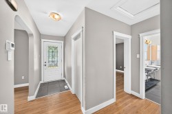 Entryway featuring a decorative glass front door, large format tile flooring, and wood-finish flooring - 