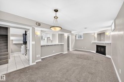 Spacious living area with wall-to-wall carpeting, a built-in fireplace, and a large pass-through window - 