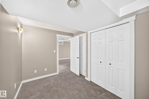 Wall-to-wall carpet flooring, neutral wall paint, and white trim throughout - 10715 133 Street Nw, Edmonton, AB 