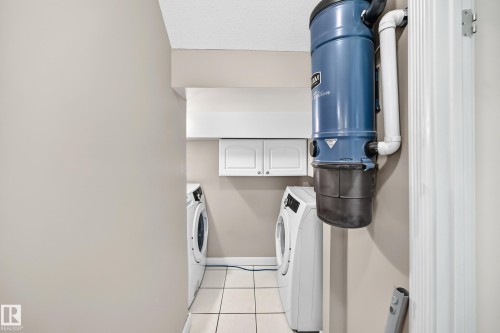 Laundry area with a built-in central vacuum system, tile flooring, and white cabinetry - 10715 133 Street Nw, Edmonton, AB 