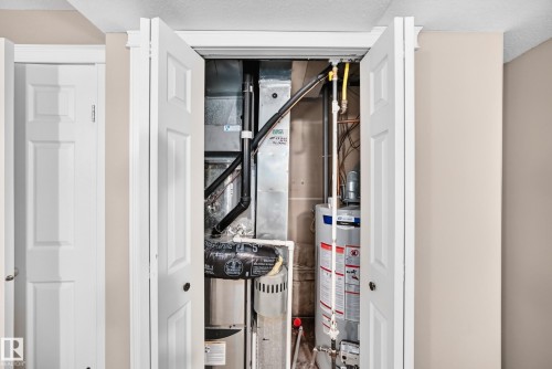Utility closet with bifold doors, containing a water heater and HVAC system - 10715 133 Street Nw, Edmonton, AB 