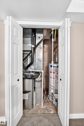 Utility closet featuring a water heater and furnace - 10715 133 Street Nw, Edmonton, AB 
