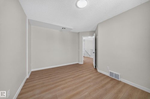 Neutral wall color, wood-finish flooring, recessed lighting, and a ceiling-mounted light fixture - 7836 7 Ave Sw Sw, Edmonton, AB 
