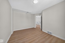 Neutral wall color, wood-finish flooring, recessed lighting, and a ceiling-mounted light fixture - 