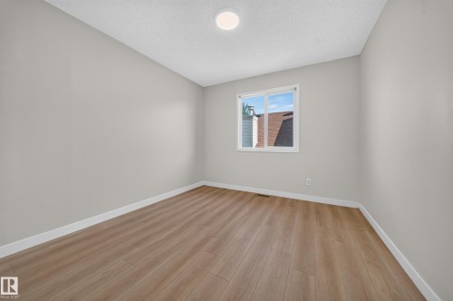 Light gray painted walls, wood-finish flooring, and a white trim - 7836 7 Ave Sw Sw, Edmonton, AB 