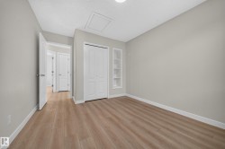 Wood-finish flooring, built-in shelving, white bi-fold closet doors, and recessed lighting - 