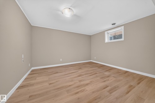 Wood-finish flooring with neutral wall tones and a ceiling-mounted light fixture - 7836 7 Ave Sw Sw, Edmonton, AB 