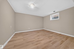 Wood-finish flooring with neutral wall tones and a ceiling-mounted light fixture - 