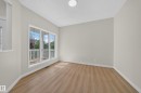 Expansive window with white trim, wood-finish flooring, light neutral wall paint, and overhead lighting - 7836 7 Ave Sw Sw, Edmonton, AB 