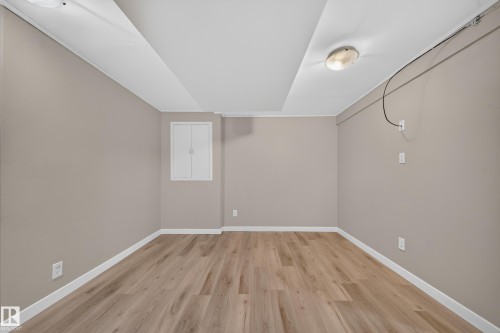 Wood-finish flooring with white trim, neutral wall paint, and overhead lighting - 7836 7 Ave Sw Sw, Edmonton, AB 
