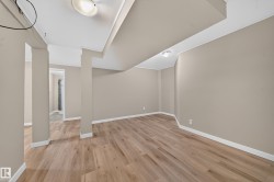 Spacious room featuring wood-finish flooring and neutral wall tones - 