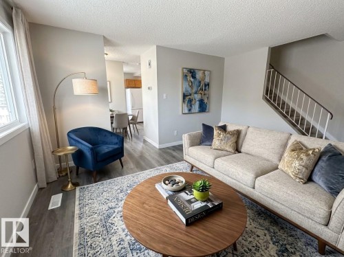 Wood-finish flooring, white trim, and light gray wall paint contribute to a neutral color palette - 9G Clareview Village Nw, Edmonton, AB 