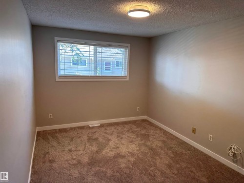 Neutral tone walls, carpeted flooring, window with blinds, and flush-mount ceiling light - 9G Clareview Village Nw, Edmonton, AB 