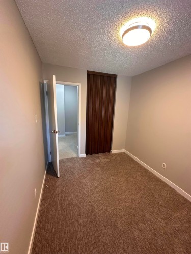Textured wall with a circular wall-mounted light fixture - 9G Clareview Village Nw, Edmonton, AB 