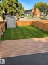 Private fenced yard featuring a storage shed, composite decking, and a grass area - 9G Clareview Village Nw, Edmonton, AB 