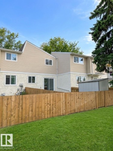 Expansive green lawn with a wood privacy fence - 9G Clareview Village Nw, Edmonton, AB 