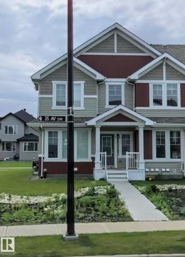 Two-story residence with a covered entry, gabled rooflines, multiple windows, and a paved walkway - 11915 35 Avenue Sw, Edmonton, AB 