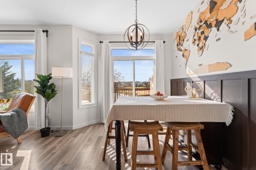 Wood-finish flooring, multiple windows, built-in wainscoting, and an orbital chandelier - #5 4900 62 St, Beaumont, AB 
