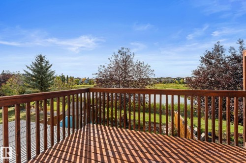 Wood-finish deck with a wood railing, offering a waterfront backdrop - #5 4900 62 St, Beaumont, AB 