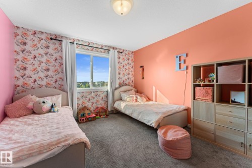 Wall-to-wall carpeting, window with outdoor scenery, and ceiling-mounted light fixture - #5 4900 62 St, Beaumont, AB 