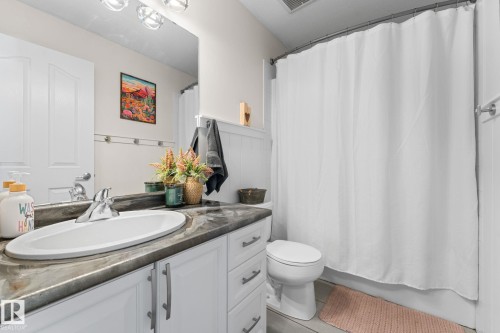 Vanity with integrated sink, chrome faucet, and dark-toned countertop - #5 4900 62 St, Beaumont, AB 