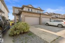Exterior featuring brick and siding finishes, two attached garage doors, concrete driveway, and established landscaping - #5 4900 62 St, Beaumont, AB 