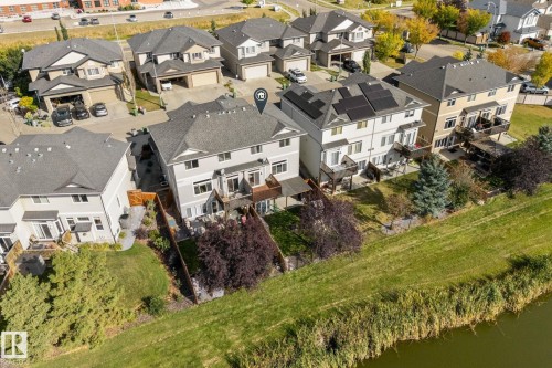 Rear exterior featuring multiple balconies, ground-level patios, and direct access to a natural waterway - #5 4900 62 St, Beaumont, AB 