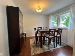 Wood-finish flooring with crisp white baseboards and a ceiling-mounted light fixture - 