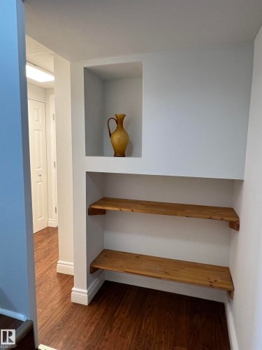 Built-in shelving unit with an upper display niche, two lower wood-finish shelves, and dark wood-finish flooring - 11908 131 Street Nw, Edmonton, AB 