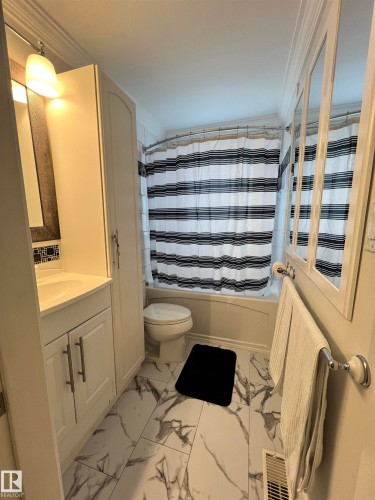 White vanity with a rectangular sink and brushed nickel hardware, paired with a tall storage cabinet - 11908 131 Street Nw, Edmonton, AB 