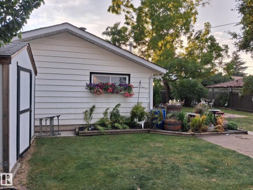 Exterior siding with a window box, a separate storage shed, a paver patio, and mature landscaping - 11908 131 Street Nw, Edmonton, AB 