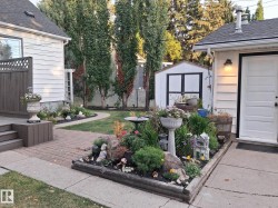 Private backyard featuring an elevated wood deck, brick paver patio, a manicured lawn, and a storage shed - 