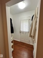Entryway featuring wood-finish flooring, white walls, and a flush-mount ceiling light - 