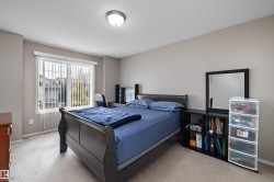 Neutral tone wall finishes, carpeting, and a window with vertical blinds - 