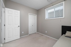 Neutral-toned walls, light-colored carpeting, white six-panel door, and white bi-fold closet doors - 