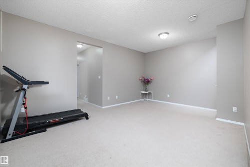 Spacious room with plush carpeting, neutral wall tones, and recessed lighting - 3114 32 Avenue Nw, Edmonton, AB 