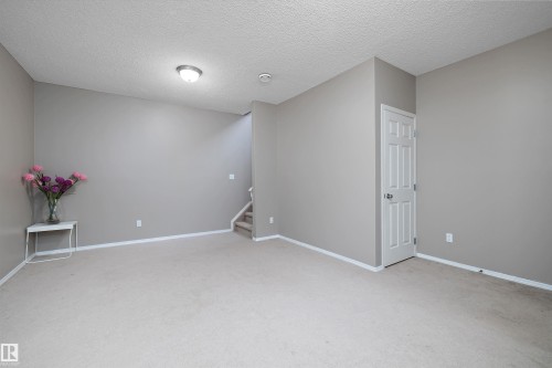 Wall-to-wall carpeting, neutral wall color, white trim, recessed lighting, and a paneled white door - 3114 32 Avenue Nw, Edmonton, AB 