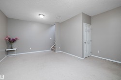 Wall-to-wall carpeting, neutral wall color, white trim, recessed lighting, and a paneled white door - 
