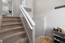 Carpeted staircase with white railings, complemented by light gray wall tones and wood-finish flooring at the base - 3114 32 Avenue Nw, Edmonton, AB 