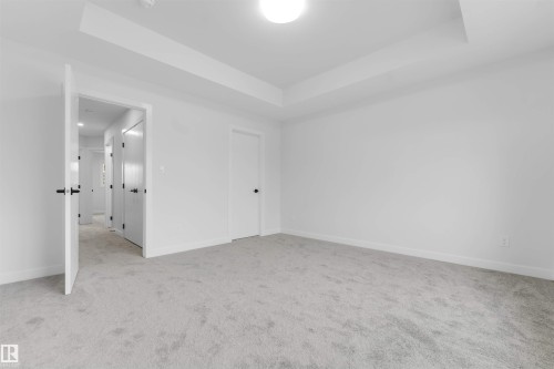 Recessed ceiling with an integrated light fixture, light gray carpeting, and white walls - 523 Robinson Blvd, Leduc, AB 